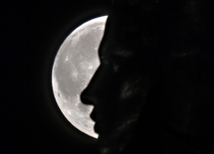 The supermoon rises through the clouds behind the "Motherland" statue, part of the WWII memorial complex, in Kiev, Ukraine, Sunday, Aug. 10, 2014.