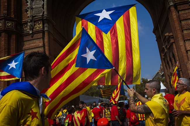 People wave “estelada” flags symbolizing Catalonia's independence in Barcelona, Spain, Thursday, Sept. 11, 2014. The region has set an Oct. 1, 2017 referendum vote to decide whether to split from Spain.