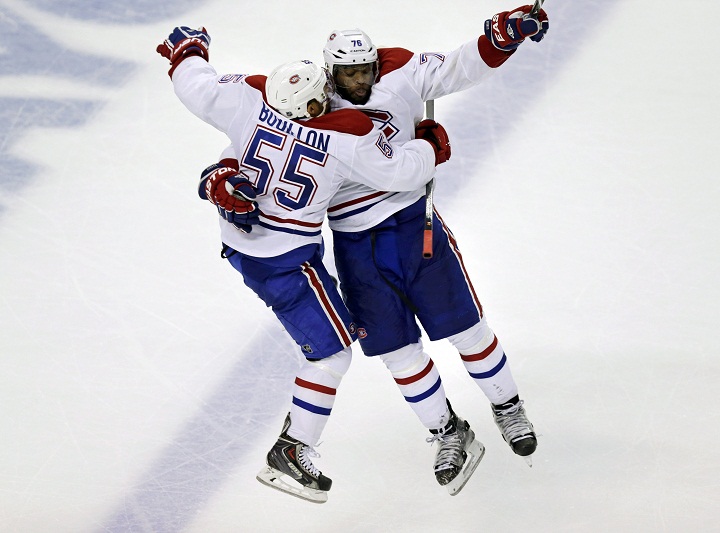 Montreal Canadiens defenseman Francis Bouillon (55) leaps into the arms of teammate P.K. Subban (76) during the third period of Game 1 in the second-round of the Stanley Cup playoff series in Boston, Thursday, May 1, 2014.