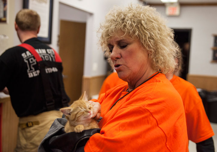 Gail Ludwick pets an orange kitten she rescued from the streets while volunteering for the Saginaw Arson Watch, Thursday, Oct. 30, 2014 at the Fraternal Order of Police Hall, 1120 South Niagara.