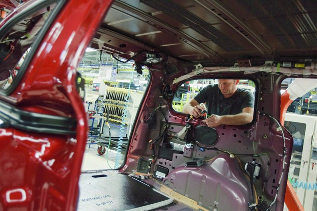 A worker installs parts on the production line at Chrysler's plant in Windsor, on January 18, 2011. THE CANADIAN PRESS/Geoff Robins