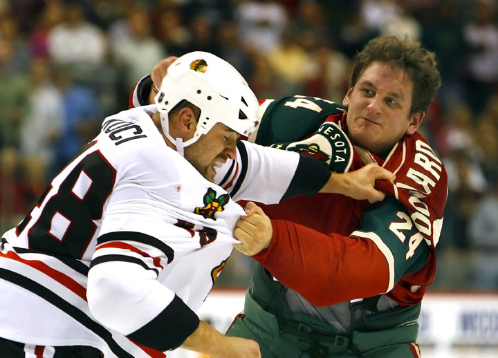 David Koci #48 of the Chicago Blackhawks and Derek Boogaard #24 of the Minnesota Wild fight in the second period of their game October 4, 2007 at the Xcel Energy Center in St. Paul, Minnesota.