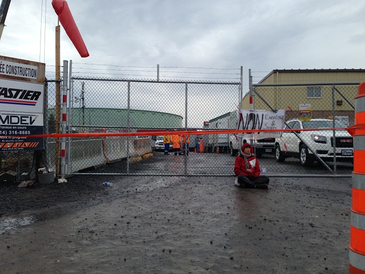 An activist chained with a bicycle u-lock and heavy chains to fences outside of an oil refinery in Montreal’s east end on October 7, 2014.
