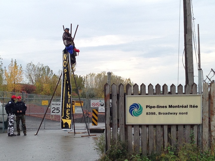 Police attempt to disassemble a tripod outside of an oil refinery in Montreal’s east end on October 7, 2014.