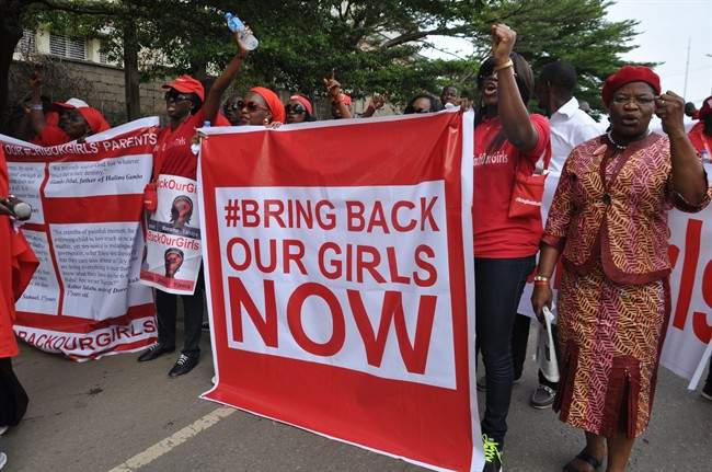 In this file photo taken Tuesday, Oct. 14, 2014, people demonstrate calling on the Nigerian government to rescue girls taken from a secondary school in Chibok region, in the city of Abuja, Nigeria.