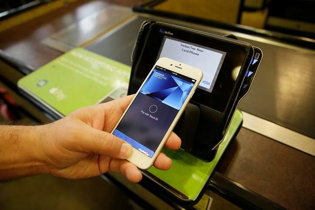Eddy Cue, Apple Senior Vice President of Internet Software and Services, demonstrates the new Apple Pay mobile payment system.