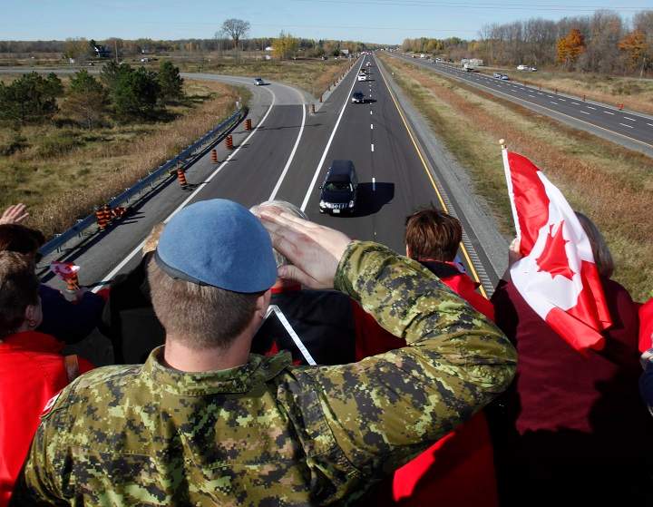 A Canadian Soldier salutes the hearse carrying the body of Cpl. Nathan Cirillo on the Veterans Memorial Highway in Ottawa on Friday, October 24, 2014.