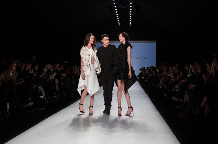 Designer Sid Neigum stands with two models after winning the Mercedes-Benz StartUp show during Toronto Fashion Week in Toronto on Monday, October 20, 2014.