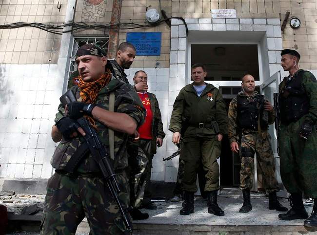 Alexander Zakharchenko, the leader of pro-Russian rebels in Donetsk, center, observes the damage at a school after shelling in the town of Donetsk, eastern Ukraine, Wednesday, Oct. 1, 2014.