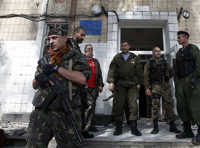 Alexander Zakharchenko, the leader of pro-Russian rebels in Donetsk, centre, observes the damage at a school after shelling in the town of Donetsk, eastern Ukraine, Wednesday, Oct. 1, 2014. 