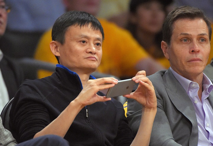 Jack Ma, left, executive chairman of Alibaba Group, watches the Los Angeles Lakers play the Houston Rockets during the first half of an NBA basketball game, Tuesday, Oct. 28, 2014, in Los Angeles.