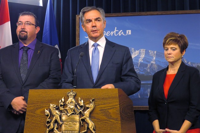 Alberta Premier Jim Prentice (centre) announces Monday, Nov.24, 2014 at legislature in Edmonton that opposition Wildrose members Ian Donovan, left, and Kerry Towle, right, have crossed the floor to join his Progressive Conservative caucus. 