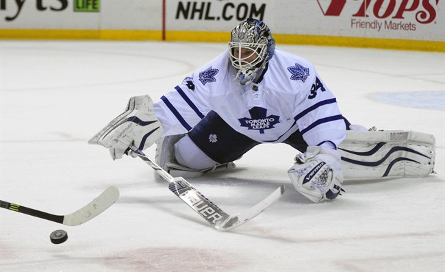 Toronto Maple Leafs goaltender James Reimer tries to poke check the puck shot by Buffalo Sabres center Brian Flynn during the first period of an NHL hockey game Saturday, Nov. 15, 2014, in Buffalo, N.Y.