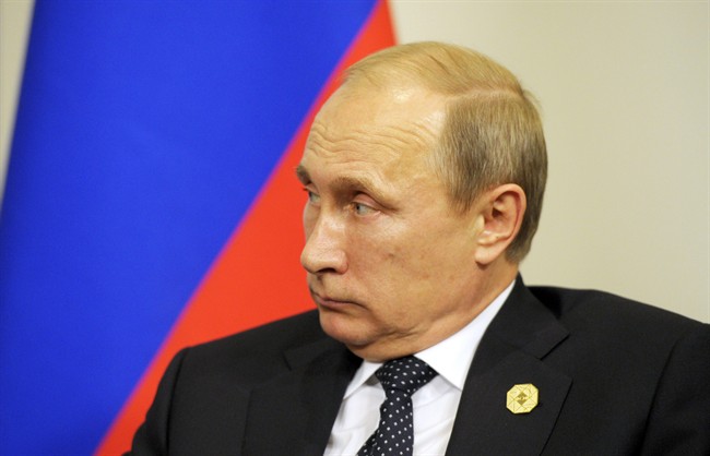 Russia's President Vladimir Putin looks over at the French president during their bilateral meeting on the sidelines of the G20 Summit in Brisbane, Australia, Saturday, Nov. 15, 2014.