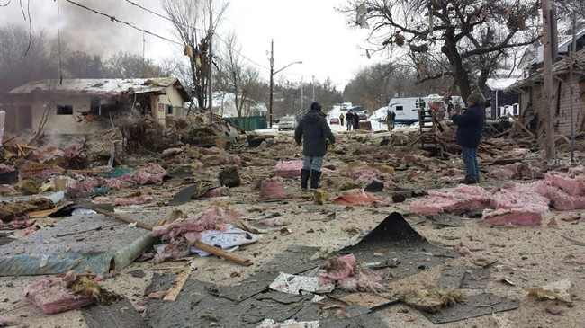 Debris from an explosion litters a street in Regina Beach, Sask., on Dec. 3, 2014.