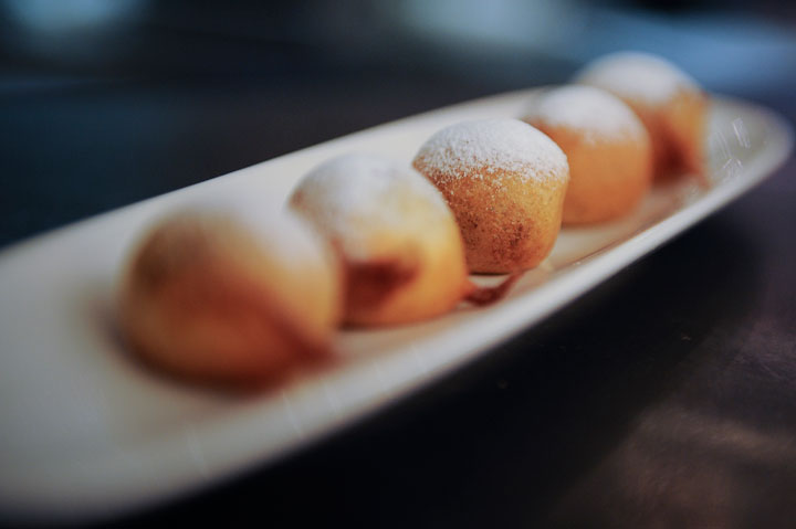 Chocolate fritters dusted with icing sugar are pictured.