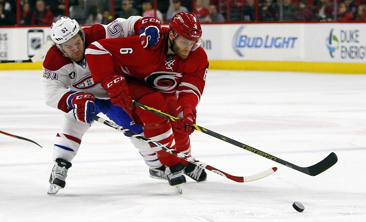 Carolina Hurricanes' Tim Gleason (6) and Montreal Canadiens' David Desharnais (51) battle for the puck during the first period of an NHL hockey game in Raleigh, N.C., Monday, Dec. 29, 2014.