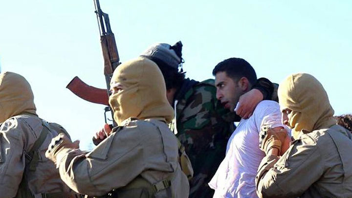 This image posted by the Raqqa Media Center of the Islamic State group, a militant extremist group, which has been authenticated based on its contents and other AP reporting, shows members of the Islamic State group with a captured pilot, center, wearing a white shirt in Raqqa, Syria, Wednesday, Dec. 24, 2014. Activists say that Islamic State fighters have shot down a warplane believed to be from the U.S.-led coalition over Syria.