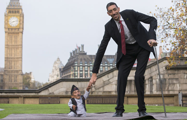 Chandra Bahadur Dangi, from Nepal, the shortest adult to have ever been verified by Guinness World Records, poses for pictures with the world’s tallest man Sultan Kosen from Turkey, during a photocall in London on November 13, 2014.