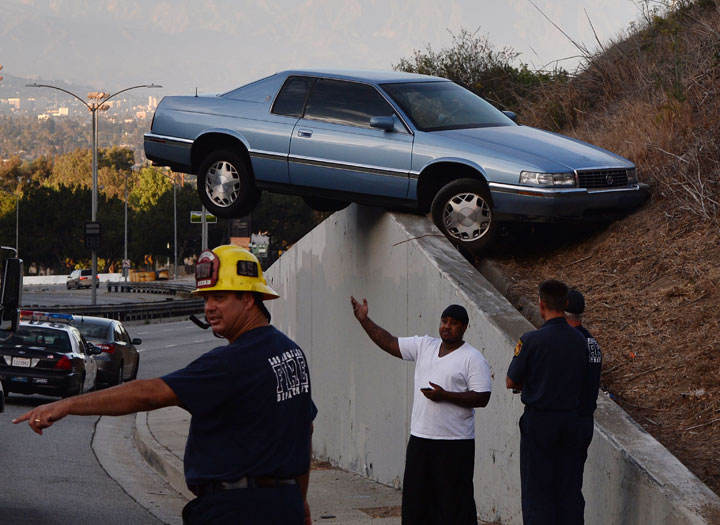 A car sits atop an embankment after the driver lost control on South La Brea Ave in Baldwin Hills, Los Angeles on August 24, 2014.