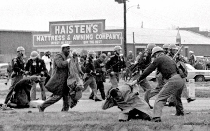 Alabama state troopers swing nightsticks to break up a civil rights voting march in Selma, Ala.