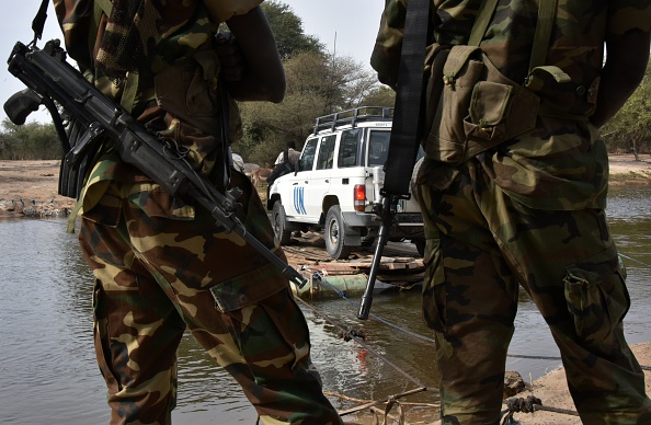 A picture taken on January 27, 2015 shows Chadian soldiers watching as a UN vehicle from a United Nations' refugee agency (UNHCR) convoy crosses a branch of lake Chad, heading to the UNHCR camp in N'Gouboua, in Chad's Lake Chad region. Since the beginning of January more than 14,000 people have fled over the Nigerian border into Chad to escape the bloody attacks by Islamist group Boko Haram around Baga, according to Mamadou Dian Balde, of the UN's refugee agency. 