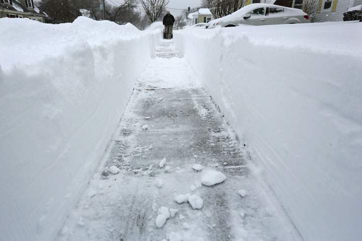 A man uses a snow blower to dig himself out of the snow on Tuesday, Jan. 27, 2015 in New Bedford, Mass.