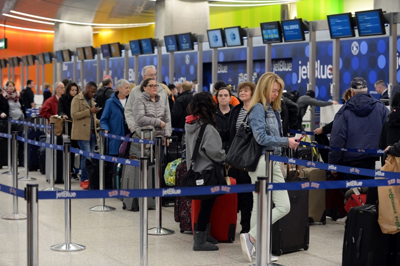 Travelers stand in line in Terminal C at Logan International Airport attempting to get out ahead of the massive storm due to hit the northeast this evening and going into Wednesday January 26, 2015 in Boston, Massachusetts.