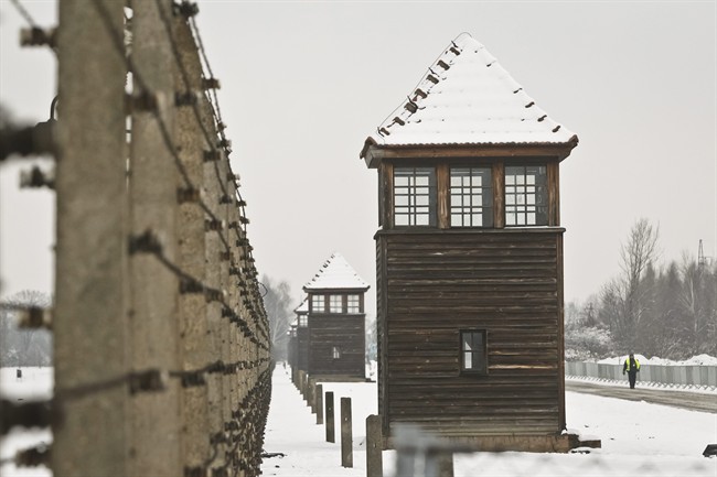 Barbed wire fences and guard towers surround the access road into the Birkenau Nazi death camp in Oswiecim, Poland, Monday, Jan. 26, 2015. 