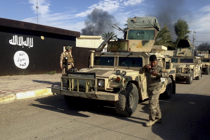 In this Monday, Nov. 24, 2014 file photo, Iraqi army soldiers deploy in front of a court run by the Islamic State group after a military operation to regain control of the town of Sadiyah in Diyala province, 95 kilometers north of Baghdad, Iraq. 