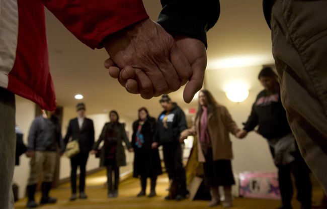 A group of aboriginal protesters hold hands during a prayer outside the National Roundtable on Missing and Murdered Indigenous Women and Girls Friday, February 27, 2015 in Ottawa.