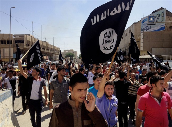 FILE - In this Monday, June 16, 2014 file photo, demonstrators chant pro-Islamic State group slogans as they wave the group's flags in front of the provincial government headquarters in Mosul, 225 miles (360 kilometers) northwest of Baghdad, Iraq.