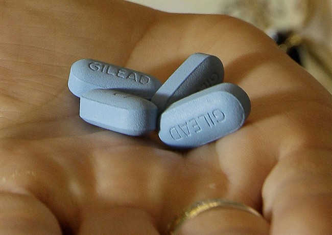 FILE - A doctor holds Truvada pills at her office in San Francisco. (AP Photo/Jeff Chiu).