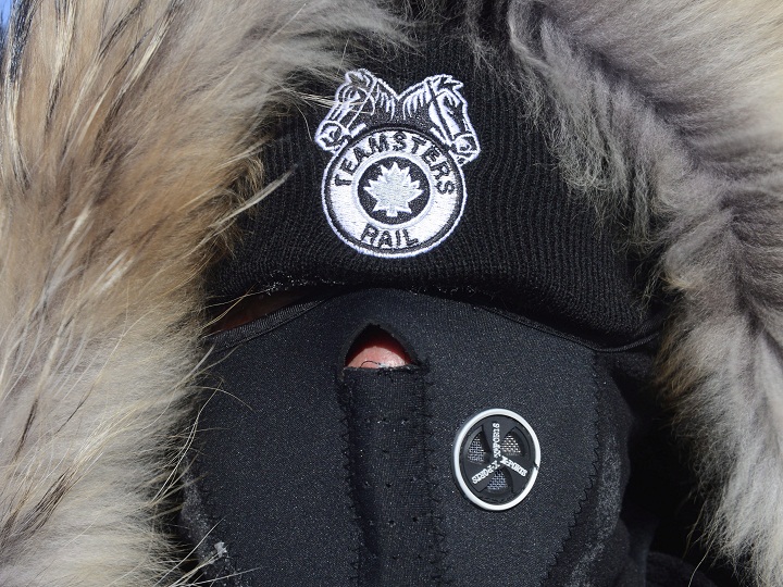 A bundled up Canadian Pacific Railway worker walks the picket line while on strike at the Cote Saint-Luc railyard in Montreal on Monday, Feb. 16, 2015.