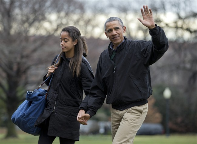 FILE – In this Jan. 4, 2015 file photo, President Barack Obama, with his daughter Malia Obama, waves as they arrive at the White House in Washington.