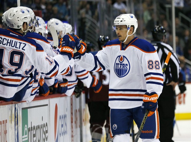 Edmonton Oilers defenseman Brandon Davidson, right, is congratulated by teammates after scoring a goal against the Colorado Avalanche in the first period of an NHL hockey game Monday, March 30, 2015, in Denver.