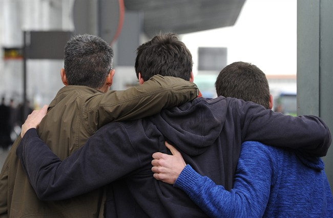 People comfort each other as they arrive at the Barcelona airport.