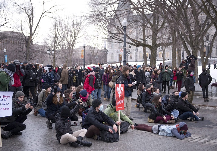 Demonstrators sit on the street at an anti-austerity protest, Thursday, March 26, 2015 in front of the legislature in Quebec City.