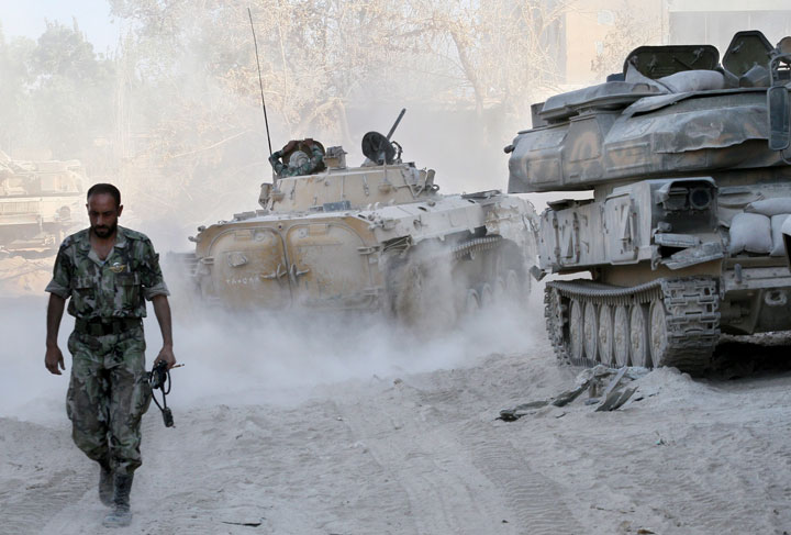 In this photo taken on a government-organized media tour, a Syrian army soldier walks on a street in Damascus, Syria, Saturday, Aug. 24, 2013. 