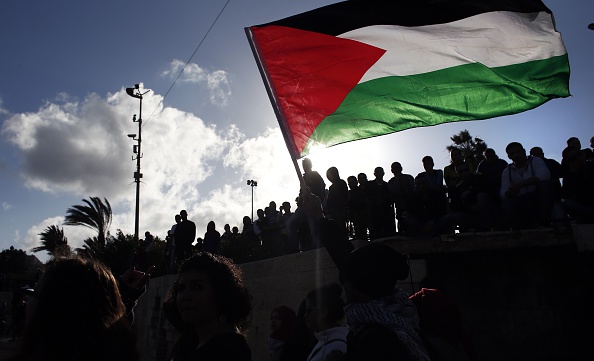 Palestinians wave a giant national flag during a demonstration marking Land Day on March 30, 2015 near the Damascus Gate in Jerusalem's Old City. 