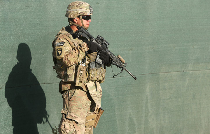 An International Security Assistance Force stands guard during a flag-lowering ceremony in Kabul, Afghanistan, Monday, Dec. 8, 2014.