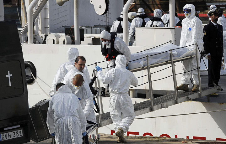 Italian Coast Guard officers disembark the body of a migrant off the ship Bruno Gregoretti, in Valletta’s Grand Harbour, Monday, April 20 2015.