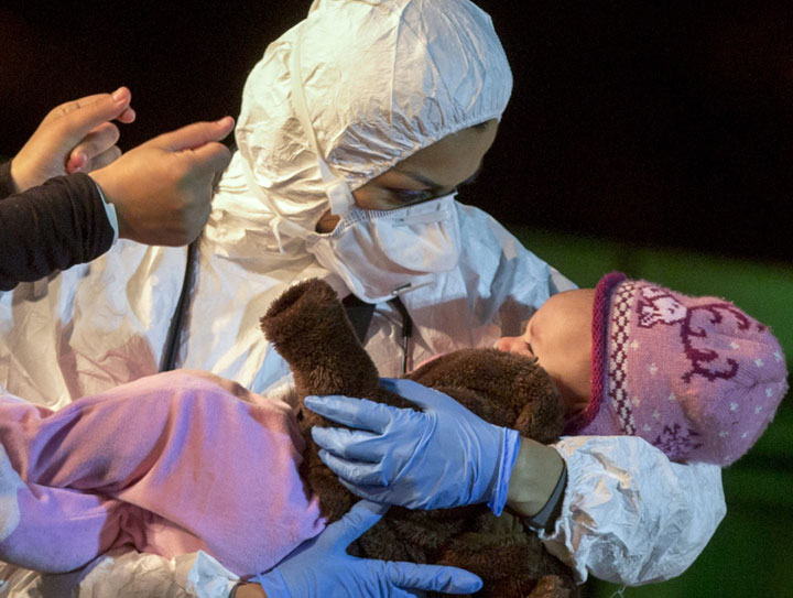 A rescuer cradles a child in the Sicilian harbor of Pozzallo, Italy, early Monday, April 20, 2015.