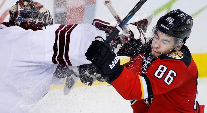Arizona Coyotes' goalie Mike Smith, left, takes a roughing penalty on Calgary Flames' Josh Jooris during third period NHL action in Calgary, Alta., Tuesday April 7, 2015. 