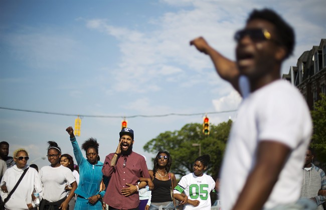Protesters link arms while marching toward City Hall to demonstrate the police-custody death of Freddie Gray, Thursday, April 30, 2015, in Baltimore. (AP Photo/David Goldman).