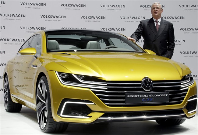 Volkswagen CEO Martin Winterkorn poses for the media beside a GTE concept car.