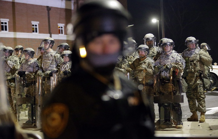 Missouri National Guard line up behind police officers monitoring protesters in front of the Ferguson Police Department Tuesday, Nov. 25, 2014, in Ferguson, Mo. Missouri’s governor ordered hundreds more state militia into Ferguson on Tuesday, after a night of protests and rioting over a grand jury’s decision not to indict police officer Darren Wilson in the fatal shooting of Michael Brown, a case that has inflamed racial tensions in the U.S.