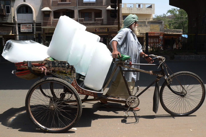 An Indian worker uses a rickshaw to transport ice from an ice factory in Amritsar on May 27, 2015.