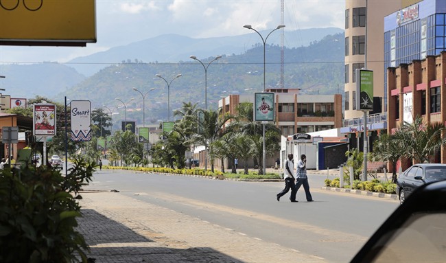 Two men walk across a deserted street in the town center of Bujumbura, Burundi, Friday, May 15, 2015. Two senior army officers and a police general accused of taking part in an attempted coup in Burundi have been arrested, a presidential spokesman said on Friday, as it became apparent that a military plot to oust President Pierre Nkurunziza had fizzled out. 
