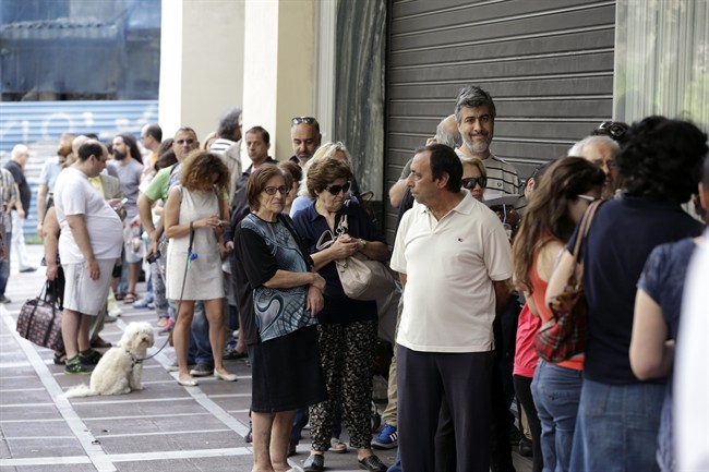 People stand in a queue outside a bank which operates on Saturday but eventually didn\’t open, in central Athens on June 27, 2015.